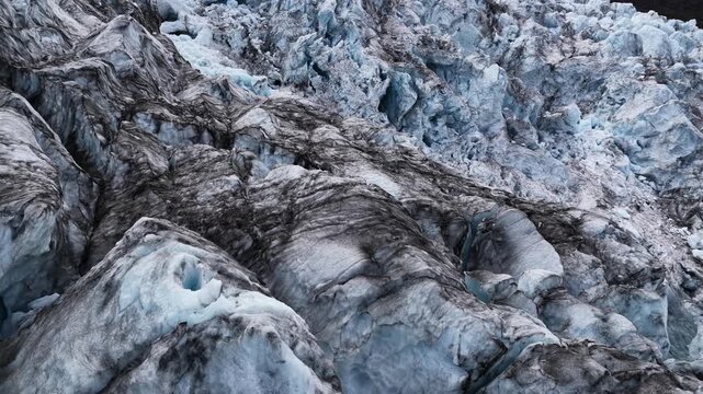 Aerial view of a glacier's jagged textures, where icy blues meet rugged grays, creating a stunning contrast of color and form, Sveitarfelagid Hornafjordur, Iceland.