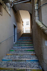 narrow street alleyway staircase with painted steps and archway in the old town