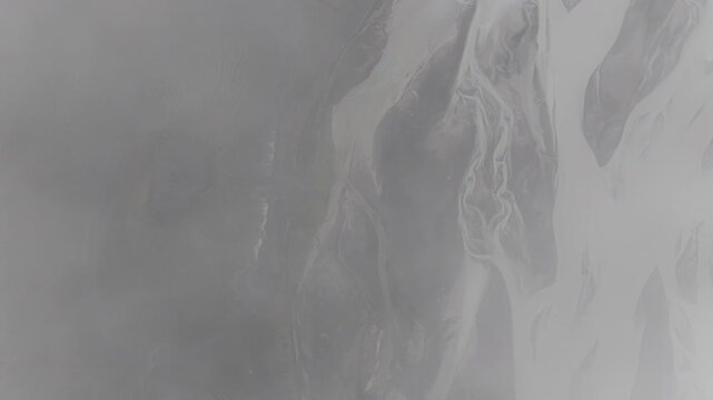Aerial view of glacial river streams cutting through volcanic ash creating a surreal landscape with stark contrasts in Landmannalaugar, Rangarthing ytra, Iceland.