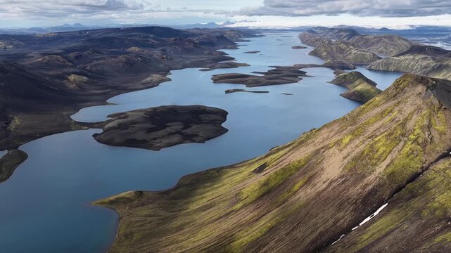 Aerial view of the tranquil Langisjor lake surrounded by rugged mountains, creating a stunning contrast of blue waters and earthy tones, Skaftarhreppur, Iceland.