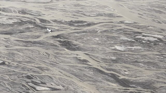 Aerial view of the stark contrast between the dark braided rivers and the light grey sands creating a mesmerizing pattern, Skaftarhreppur, Iceland.