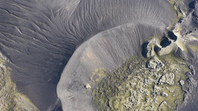 Aerial view of the stark, volcanic landscape with contrasting black lava fields and patches of green moss, Laki volcano, Skaftarhreppur, Iceland.