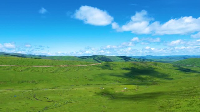 Aerial View of Rolling Green Grassland with Livestock and Hills