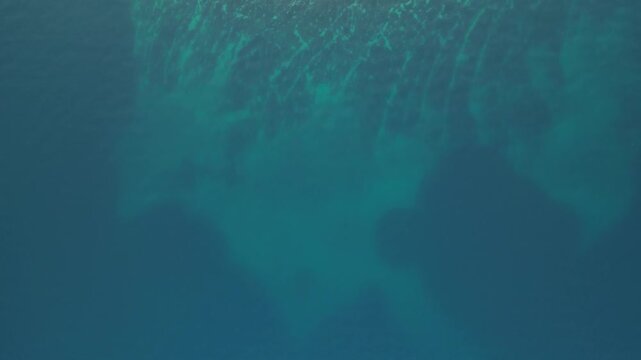 Aerial view of an island with lush green vegetation and rocky shoreline surrounded by turquoise waters with a boat nearby, Biograd na Moru, Zadar County, Croatia.