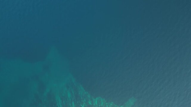 Aerial view of a small, rocky island with sparse green vegetation surrounded by turquoise waters, creating a striking contrast, Biograd na Moru, Zadar County, Croatia.