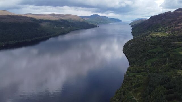Aerial view of Loch Ness's tranquil waters reflecting skies, flanked by lush green hills near Fort Augustus, creating a serene Scottish landscape, Fort Augustus, Scotland, United Kingdom.