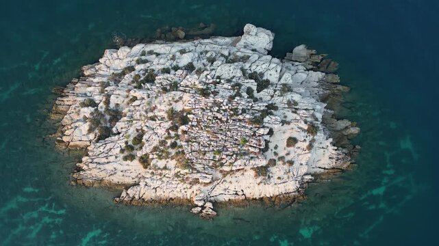 Aerial view of a small rocky island surrounded by turquoise waters creating a striking contrast with the white stone, Biograd na Moru, Zadar County, Croatia.