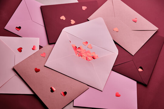 Heart confetti spilling from love letter envelopes