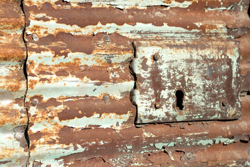 Peeling paint and rusted metal with keyhole