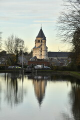 Le clocher de la collégiale Sainte-Gertrude se reflétant dans les eaux de l'étang du parc de la Dodaine en fin de journée d'automne à Nivelles (Brabant Wallon)