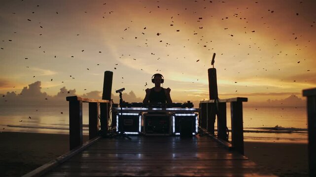 an energetic scene of a silhouette dj with hands raised performing on a beach pier during a golden sunset 
