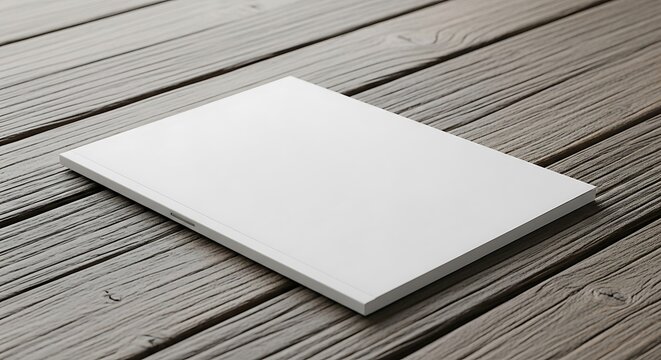 A blank white book or magazine cover mockup lying diagonally on a rustic wooden table, ready for custom design or branding presentation