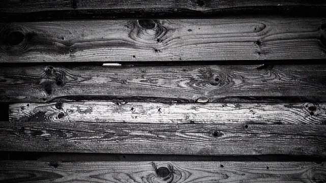 Dark monochrome texture of old weathered horizontal wooden planks slowly zooming background footage clip dramatic high contrast vintage wood grain abstract wall movement dynamic effect
