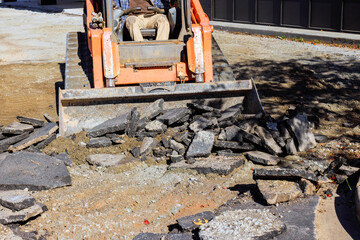 Skid steer machinery removes broken asphalt at construction site preparing for new parking lot © ungvar