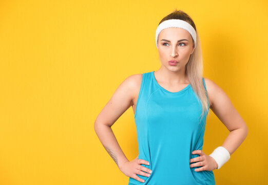 Young sportswoman with purses lips being questioned while thinking, fitness girl looking up and need inspiration, isolated on yellow background. 80s styling