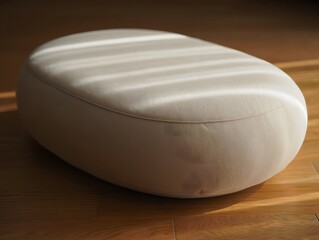 Soft oval ottoman illuminated by natural light