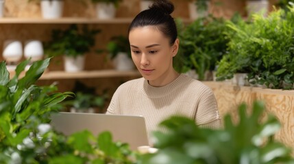 Digital Nature: A focused woman sits amid a lush display of plants and uses her laptop. She blends the natural world with modern technology.