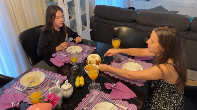 M&atilde;e e filha tomando caf&eacute; da manha juntas em casa 