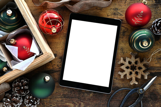 Christmas holiday decor with tablet computer blank screen; digital advertisement or website mock up