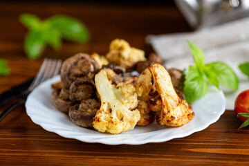 Roasted cauliflower and mushrooms served on white ceramic plate