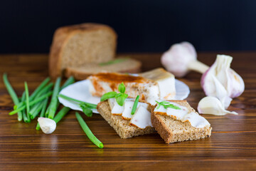 Black bread with lard and onions on a wooden table