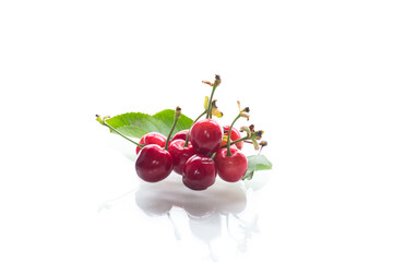 a handful of ripe red cherries on a white background