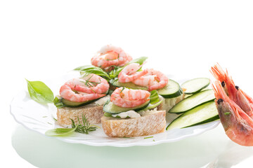 Delicious portioned appetizers with shrimps and greens on a white background