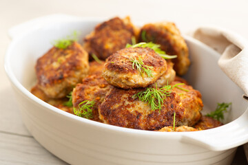 Appetizing juicy cutlets in ceramic dishes on a light background