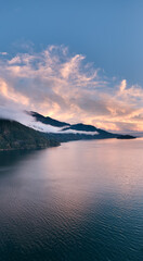 Fototapeta premium Sunset Over Coastal Mountains in British Columbia, Canada, Calm Water and Mist at Dusk