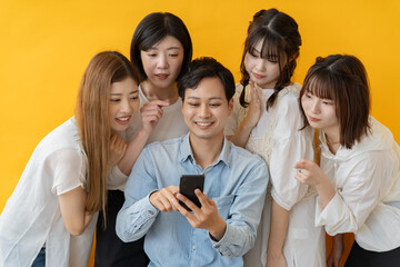 スマホ画面を囲んで楽しむ若者グループの笑顔の瞬間