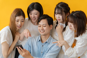 スマホ画面を囲んで楽しむ若者グループの笑顔の瞬間