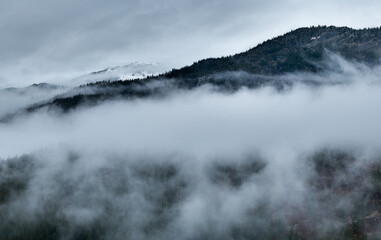 Misty Mountains Shrouded in Fog Over Forested Peaks in BC, Canada