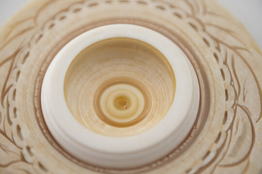 Close up of a stoma appliance with a beige wafer and a clear ostomy bag opening