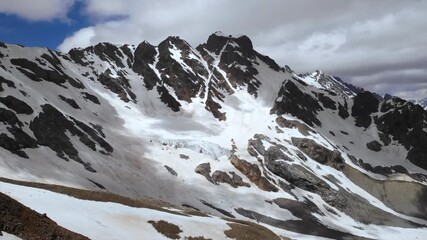 stormy mountain scenery, overcast skies and gusty winds craft dramatic mountain landscape for route assessment. Media