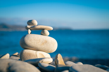 Organic balancing stones in blue ocean. Modern balance minimalism. Sea beach sculpture mood stone. Pebble geometric rock art.