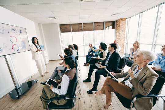 Professional team meeting in modern office with diverse coworkers attending a presentation and collaborating effectively