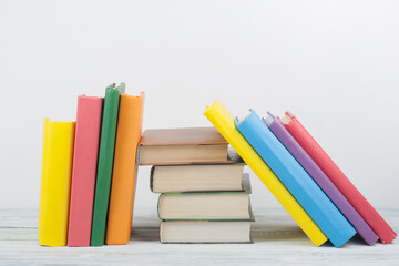 Book stacking. Open book, hardback books on wooden table and blue background. Back to school. Copy space for text.