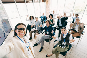 Diverse team members in formal attire celebrating together at a workplace meeting, teamwork and positive collaboration depicted indoors