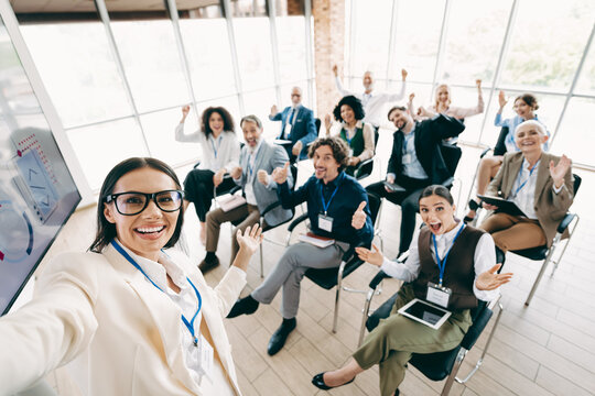 Diverse team members in formal attire celebrating together at a workplace meeting, teamwork and positive collaboration depicted indoors