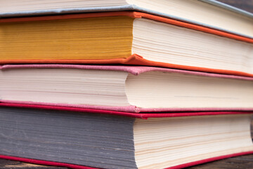 Multi-colored books on wooden table. Back to school. Copy space for text. Education business concept.