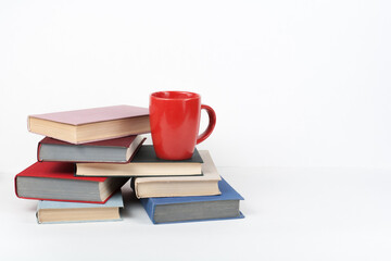 Open book, hardback colorful books on wooden table, white background. Back to school. Cup. Copy space for text. Education business concept.