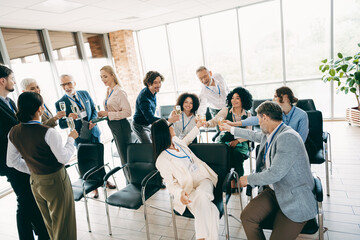 Coworkers celebrating success during a corporate meeting in an office space, showcasing teamwork and collaboration