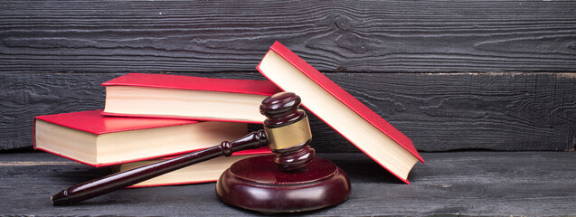 Law concept - Open law book with a wooden judges gavel on table in a courtroom or law enforcement office isolated on white background. panorama, banner.