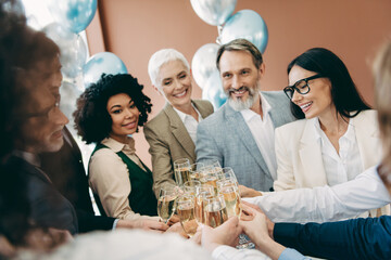 Group of professionals celebrating success at a corporate event with champagne glasses and friendly smiles indoors