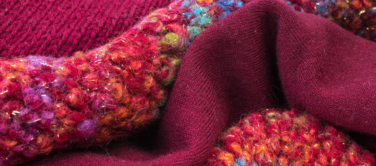 Knitted woolen sweaters. A bunch of knitted winter, autumn clothes, sweaters, knitwear, space for the text.