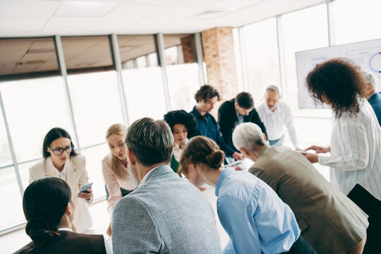 Collaborative team discussion taking place in a modern office space environment, showcasing teamwork, cooperation, and project planning