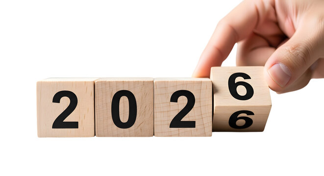 Hand turning wooden blocks from 2026 to 2027 on black background