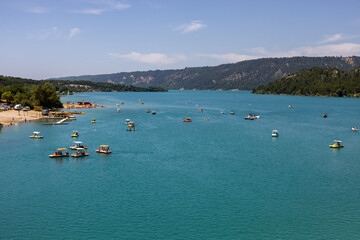  Tourists sail on the Lake of Sainte-Croix in pedal boats, kayaks and paddle boats. An ideal place for an active holiday in Provence-Alpes-C&ocirc;te d'Azur, France.