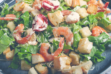 Caesar salad, with shrimp, on a marble background, top view, no people,