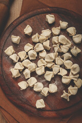 Traditional Turkish dumplings,raw, on a cutting board, top view, no people,